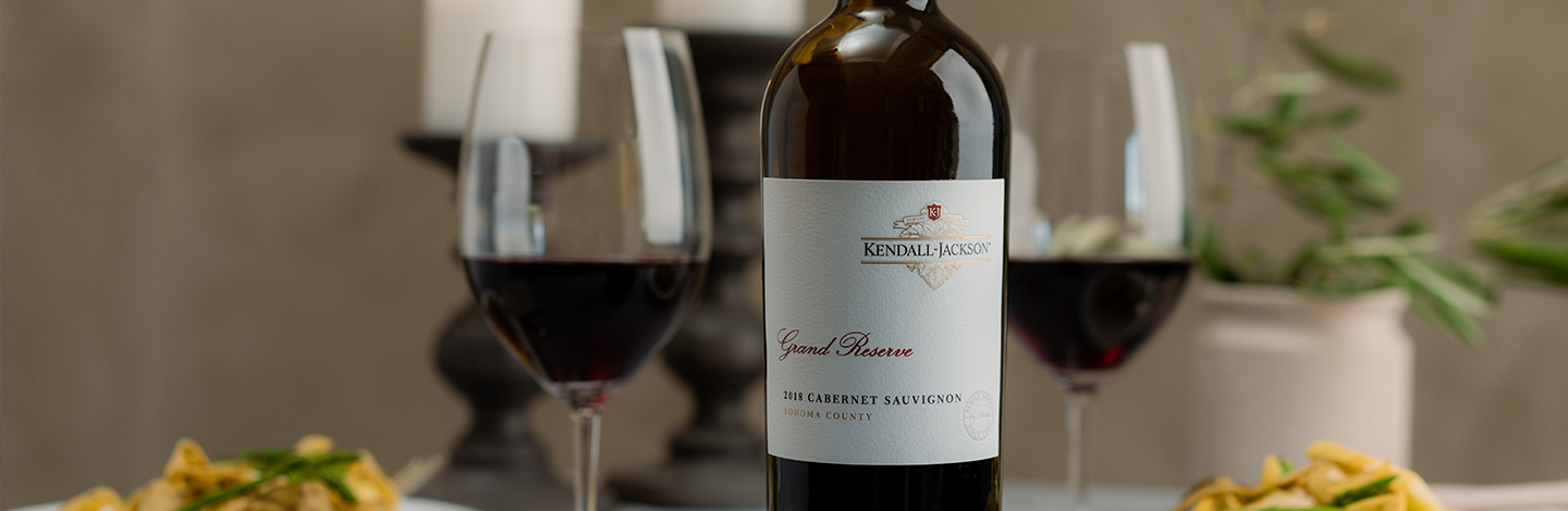 Close up of Kendall-Jackson Grand Reserve Cabernet Sauvignon with glasses half full of red wine.
